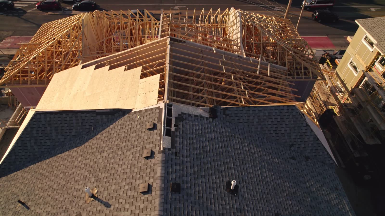 Aerial view of a roof installation in progress by Roofs and Gutter, with new asphalt shingles and wood trusses